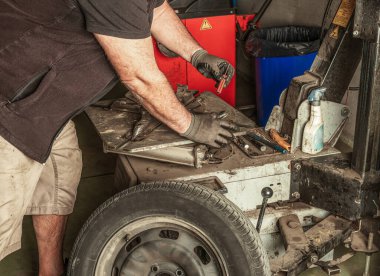 Tamirci bir arabanın valfini sökmek için bir araç alır