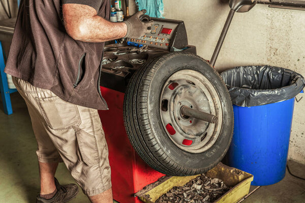 Механик ищет инструменты для ремонта колеса