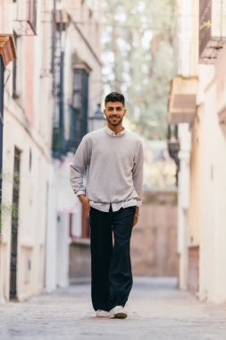 Bir adam kaldırım taşı caddesinde mutlu bir şekilde yürüyor.