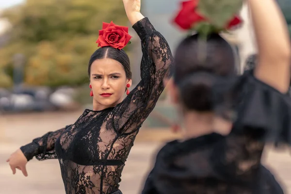 Ragazza spagnola che balla il flamenco con orecchini rossi, rosa rossa e labbra dipinte di rosso — Foto Stock