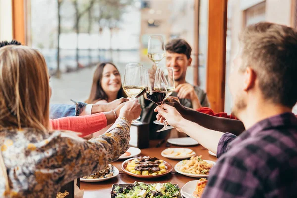 Bir grup arkadaş bir restoranın içinde kadeh kaldırıyor.