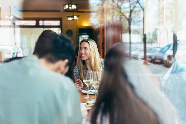 Mujer caucásica vista por una ventana de cristal dentro de un restaurante — Foto de Stock