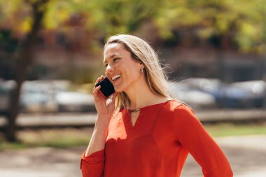 happy young Caucasian woman talking on cell phone