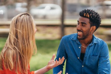 young african american man smiles as he listens attentively to his white girlfriend