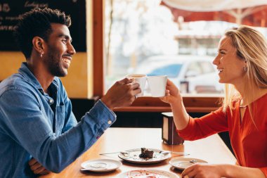 Bir fincan kahveyle kadeh kaldıran ırklar arası bir çift.