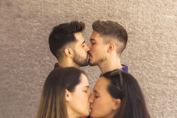 Gay couple kissing on the lips in front of a lesbian couple — Stock Photo, Image