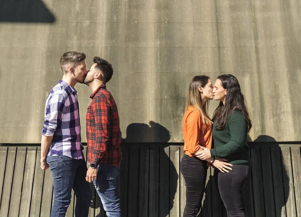 Lesbian and gay couple kissing each other on the lips — Stockfoto