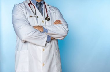 Beyaz önlüklü doktor ve çapraz kollu steteskop.