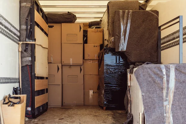 Bir kamyonun içinde taşınan bir sürü kutu ve paketin tam görüntüsü.