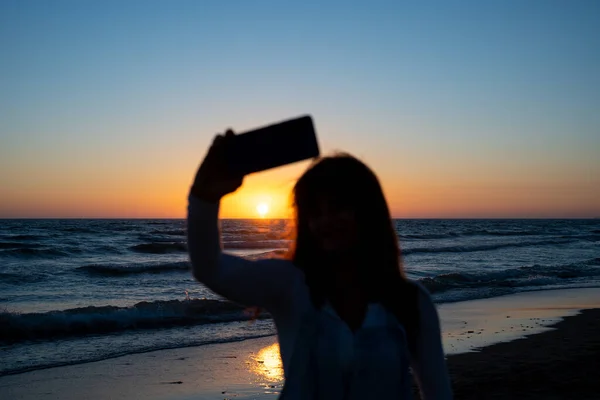 Средний Снимок Женщины Подсветкой Делающей Селфи Заката Море — стоковое фото