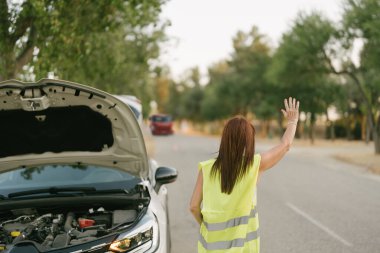 Kadın elini kaldırdı. Çekiciyi ona yardım etmesi için uyardı.
