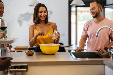 Latin kadın iki arkadaşıyla gülerken salata hazırlıyor. Sağlıklı yemek.