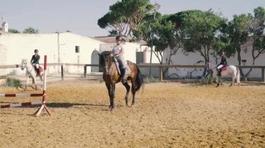 4K 'da binicilik biniciliğinde bir atla çapraz adım atan bir kadın binicinin videosu var. Yüksek kalite 4k görüntü