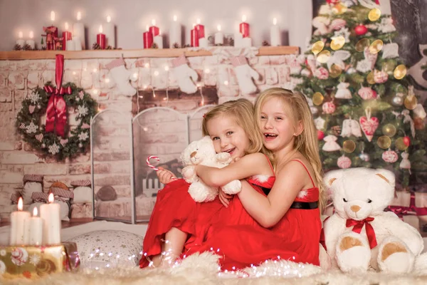 Dwie słodkie wesołe dziewczyny w Boże Narodzenie ubrania na tle choinki — Zdjęcie stockowe