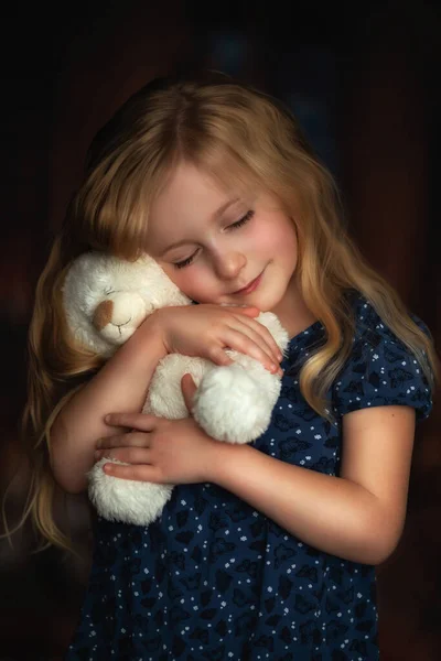 Pequeña linda chica abraza oso de peluche con los ojos cerrados —  Fotos de Stock