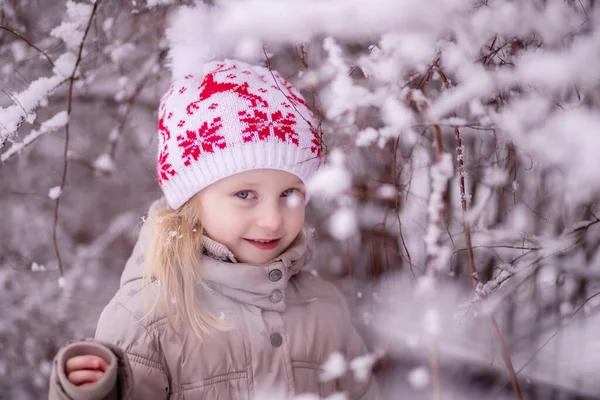 Kar parkının arka planında beyaz noel şapkalı küçük bir kızın yakın plan portresi. Boşluğu kopyala. — Stok fotoğraf