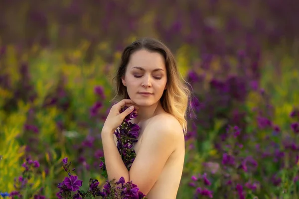 Bella ragazza spogliata in un campo di fiori — Foto Stock