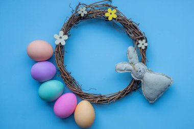 Mutlu Paskalyalar. Tatil hazırlığı. Paskalya yumurtaları ve tavşanlar modayı takip eden mavi arka planda izole edilmiş. Basit minimalizm düz görünüm kopyalama alanı.