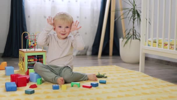 Un bambino chiude e apre il viso con i palmi delle mani ridendo allegramente. peekaboo — Video Stock