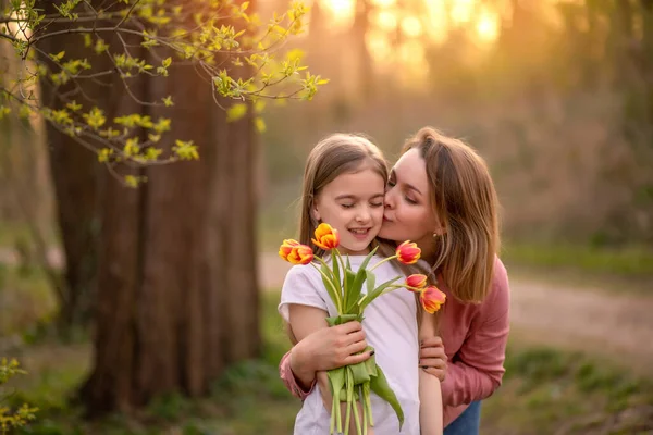 Szczęśliwego Dnia Matki. córka gratuluje matce i daje bukiet kwiatów tulipanom — Zdjęcie stockowe