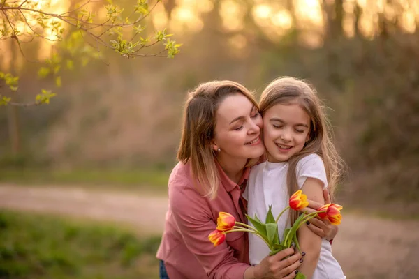 Szczęśliwego Dnia Matki. córka gratuluje matce i daje bukiet kwiatów tulipanom — Zdjęcie stockowe
