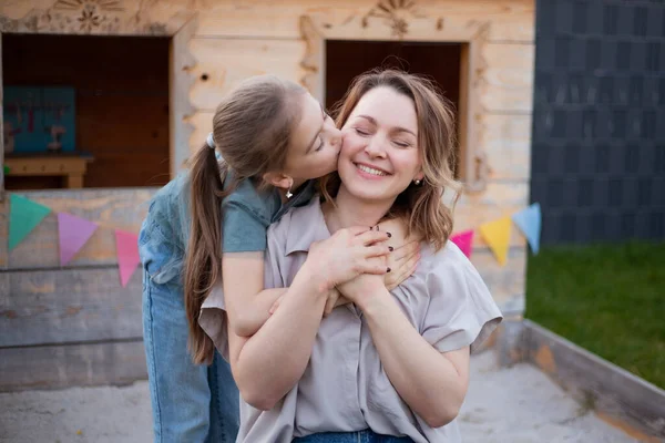 Córka przytulanie i całowanie mama, dzień matki — Zdjęcie stockowe