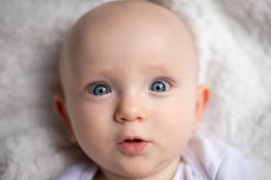 Çocuk portresi. Parlak mavi gözlü bir yüze yakın çekim. Bebekler, gözler, mutluluk, dünyayı keşfetmek, neşe, ebeveynlik, portre kavramları.