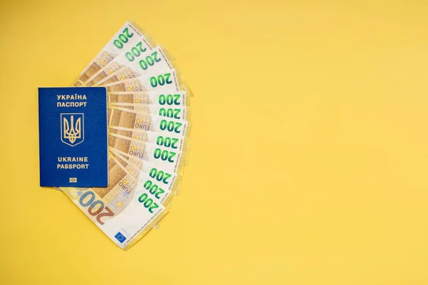 Passport of Ukraine, with euro banknotes on a yellow background. the concept of money, social assistance, travel, emigration, social payments.