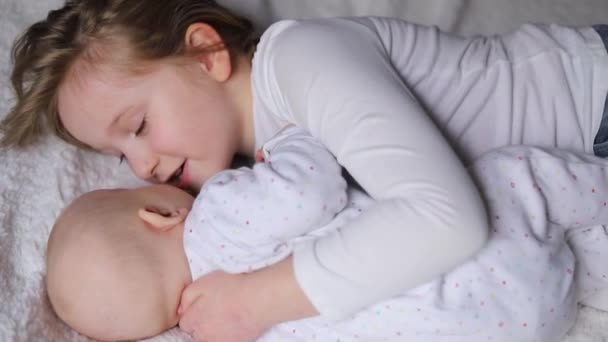 Happy Kids Toddler Older Sister Hugging Home White Blanket Smiling — Videoclip de stoc