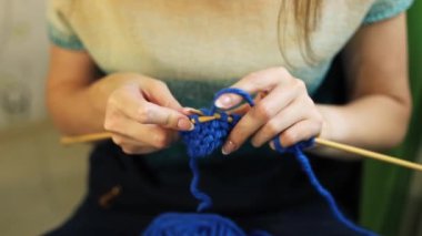 Womens hands knit with knitting needles from woolen, cotton threads. Hobbies and needlework from handmade yarn.