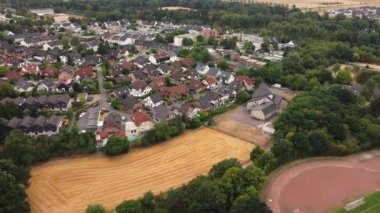 aerial drone shot from a birds eye view of a typical small old town in germany, stadium and field.