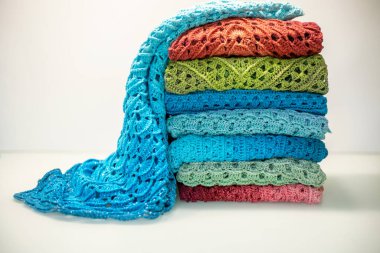a stack of multi-colored knitted things on a white background.