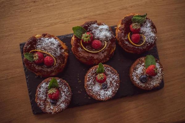 gluten-free cakes decorated with strawberries, blueberries and mint leaves.