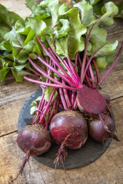 Tahta mutfak masasında taze organik sulu pancar kökü. Organik beslenme ve sonbahar sebze toplama kavramı.. 