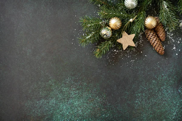 Yılbaşı ya da yeni yıl planı köknar ağacı dalı ve koyu yeşil taş arka planda Noel hediyesi. Tatil konsepti. Düz yatıyordu.