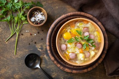 Çek yemeği: Geleneksel Zelnacka lahana çorbası sosis ve sebzeler kırsal ahşap masada bir kasede. Üst görünüm düz arkaplan.