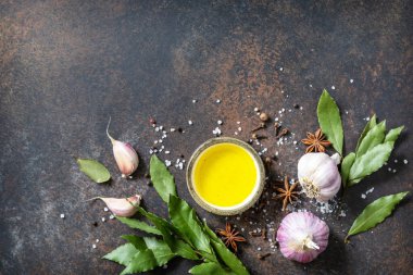 Mutfak yemekleri geçmişi. Koyun yaprakları sarımsak, biberiye, defne yaprağı, biber ve zeytinyağı ile birlikte, taş gibi bir masada. Üst görünüm düz arkaplan. Boşluğu kopyala.