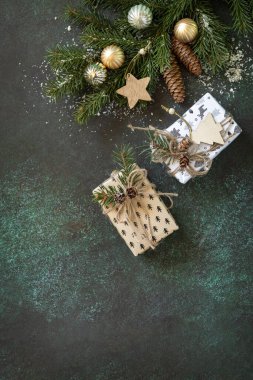 Köknar ağacı dalı ve koyu yeşil taştan bir arka planda Noel hediyesi olan Noel düzeni. Kış el sanatları. Kutlama Xmas 'ı için hazırlık. Boşluğu kopyala.