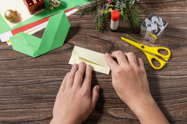 Talimat adım 7. Noel tebrik kartı hediye origami mumu ahşap masada. Çocuk sanat projesi, el yapımı, çocuklar için el işi..