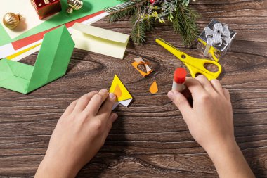 Talimat adım 9. Noel tebrik kartı hediye origami mumu ahşap masada. Çocuk sanat projesi, el yapımı, çocuklar için el işi..