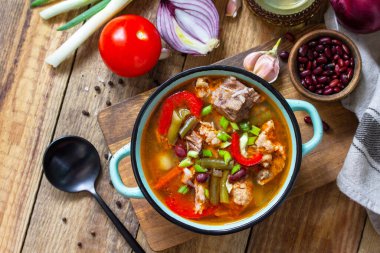 Geleneksel İngiliz çorbası biftek, fasulye ve sebzeler ahşap bir masada. Sıcak yemek ya da öğle yemeği. En üstteki düz yerde. Boşluğu kopyala.