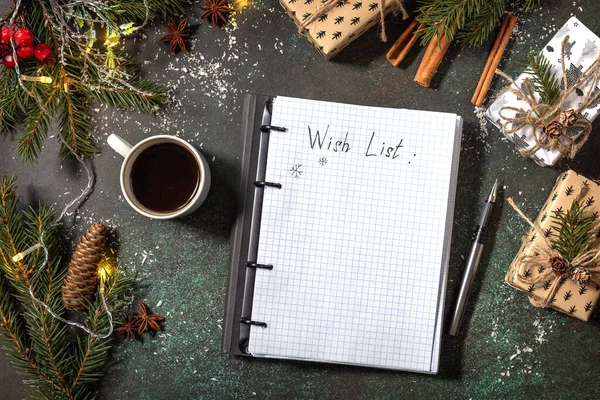 Open planner Notebook with empty wich list and cup of coffee on xmas dark stone tabletop. New year or christmas planning concept. Flat lay.