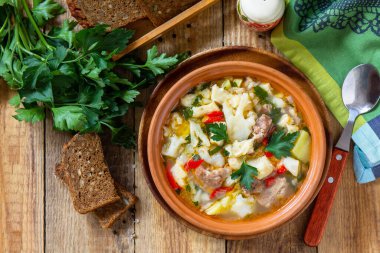 Geleneksel Macar çorbası, ahşap bir masada sığır eti, sebze ve hamur tatlısı. Sıcak yemek ya da öğle yemeği. Düz yatış, üst görünüm. 