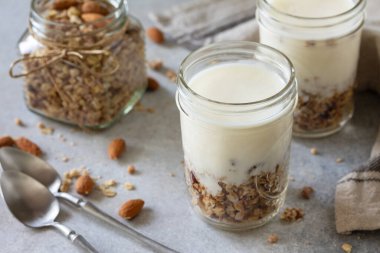 Healthy breakfast, yogurt parfait. Yogurt with homemade almond granola on a gray concrete background. 