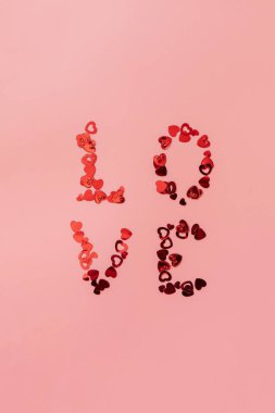 Sevgililer Günü, aşk ve düğün konsepti. Pembe arka planda aşk kırmızı kalpleri. Düz yatış, üst görünüm. 