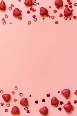 Sevgililer Günü, aşk ve düğün fikri. Pembe arka plandaki kırmızı kalpleri çerçevele. Düz yerde, üst tarafta. Boşluğu kopyala.