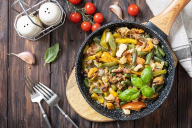 Deniz ürünleri yahnisi, sağlıklı Akdeniz yemeği. Karides, kalamar, sebze ve sarımsak soslu mürekkep balığı kızartma tavasında, ahşap bir masada. Üst görünüm düzlüğü. 