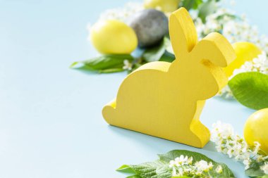 Tavşanlı mutlu Paskalya konsepti, doğal renkli paskalya yumurtaları ve mavi arka planda bahar çiçekleri. Paskalya geçmişi. Boşluğu kopyala.