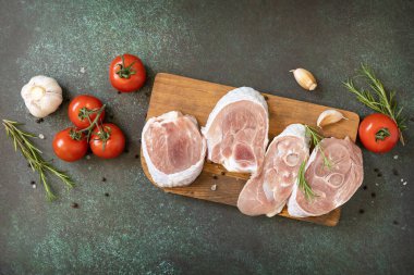 Biberiyeli çiğ hindi ve siyah taş bir masanın üstünde baharatlar. Izgara için çiğ biftek. Üst görünüm düz arkaplan. 