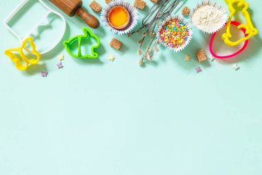 Pişirme ya da pişirme geçmişi. Paskalya festivali için gerekli malzemeler. Mutfak aletleri, un, esmer şeker, açık yeşil arka planda yumurta ve tereyağı. En üstteki düz yerde. Boşluğu kopyala.